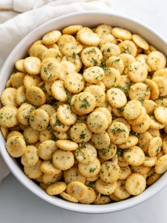 A white bowl filled with Ranch Oyster Crackers with seasonings.