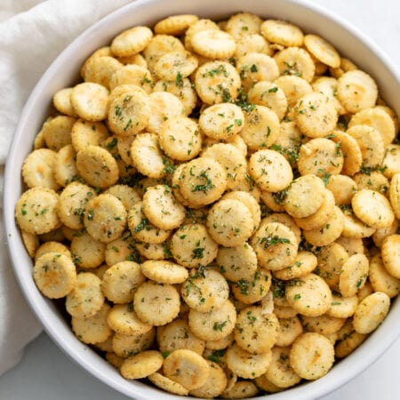 A white bowl filled with Ranch Oyster Crackers with seasonings.