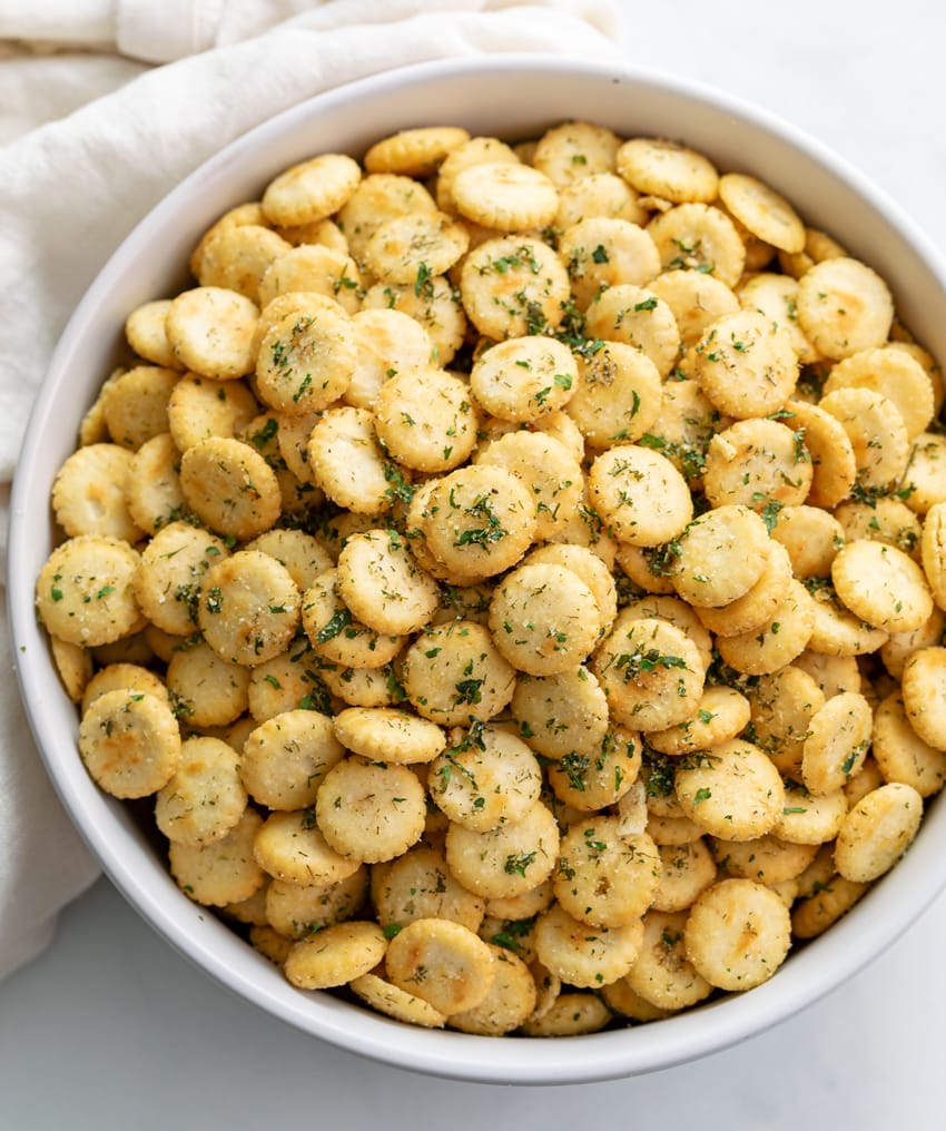 A white bowl filled with Ranch Oyster Crackers with seasonings.