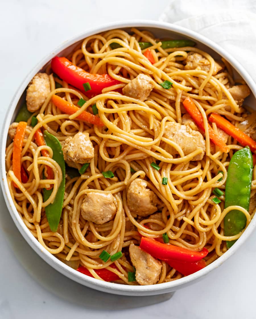 Chicken Lo Mein in a white bowl with vegetables, sauce, and chicken.