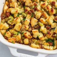Sausage Stuffing in a White Casserole dish with parsley on top.