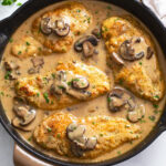 A black skillet with Chicken Marsala in a wine sauce with mushrooms and parsley.