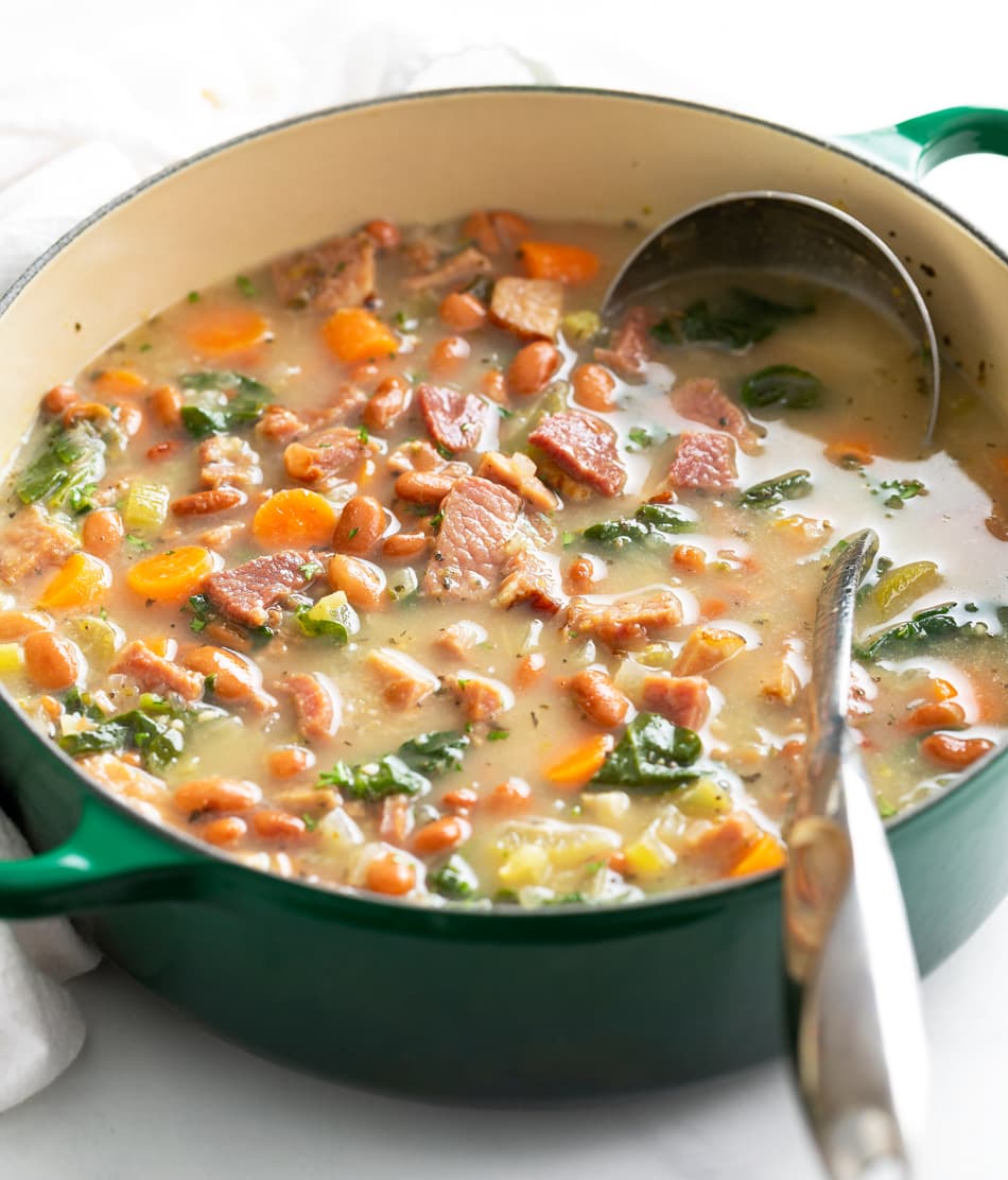 Ham Soup in a green Dutch oven with a metal ladle.