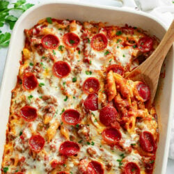 A labeled image of Pizza Pasta in a casserole dish with a wooden spoon.
