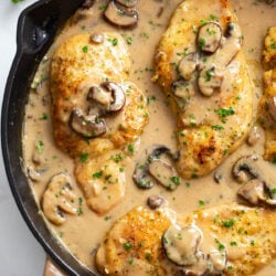 Chicken Marsala in a skillet with marsala wine sauce with mushrooms.