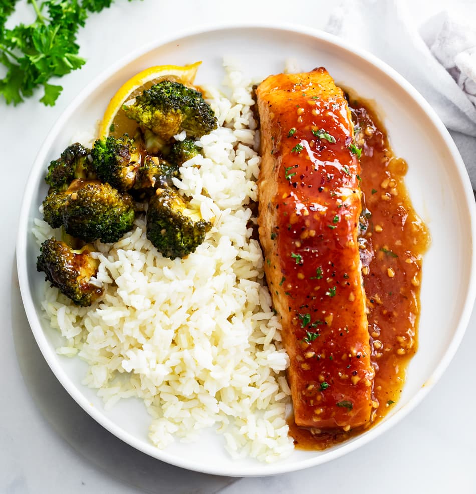 Honey Glazed Salmon on a white plate with rice and broccoli.