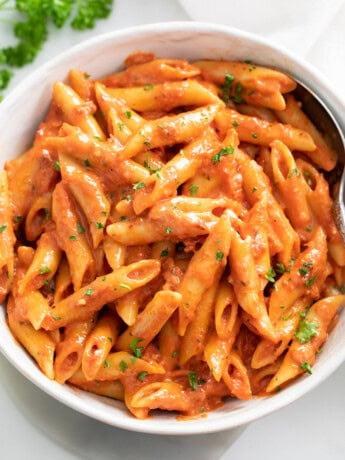 A bowl of Penne Alla Vodka with parsley on top.