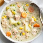 Creamy Chicken Soup in a white soup bowl with a spoon on the right side.