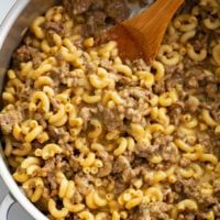 Homemade Hamburger Helper in a skillet with a wooden spoon.
