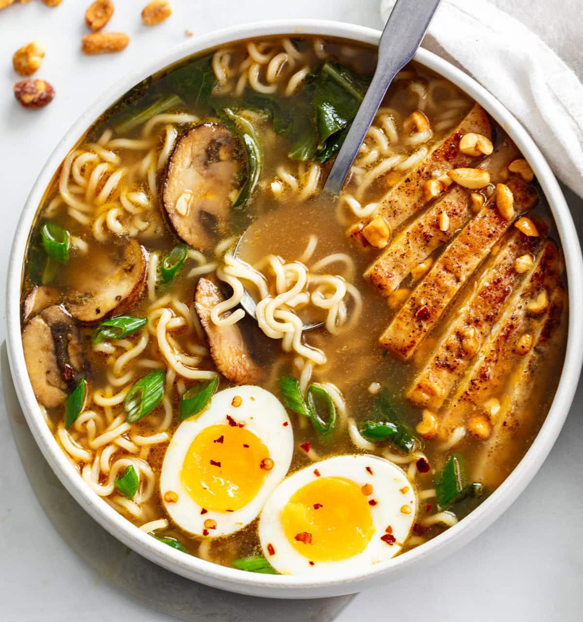 Homemade Ramen in a soup bowl with chicken, mushrooms, Bok Choy, and soft boiled eggs.