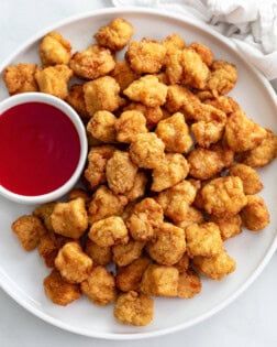 Popcorn Chicken on a white plate with sweet and sour sauce.