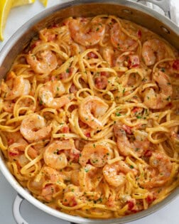 A skillet of shrimp pasta with linguine in a creamy sauce.