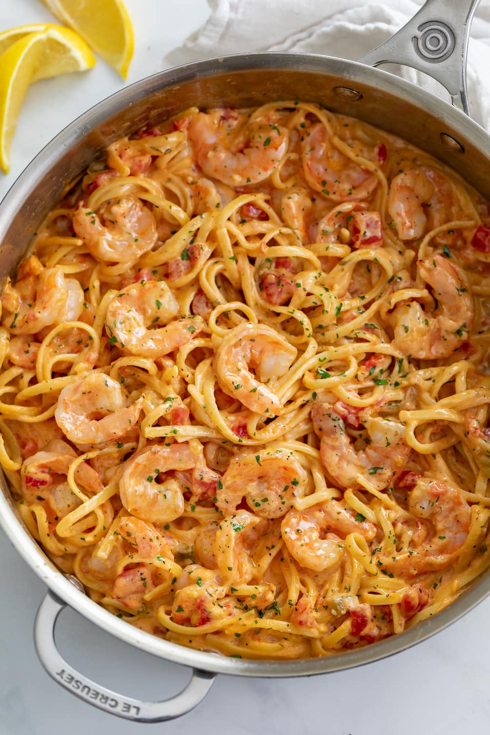 A skillet of Creamy Shrimp Pasta with diced tomatoes and linguine.