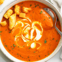 Roasted Red Pepper Soup topped with croutons and a swirl of cream.