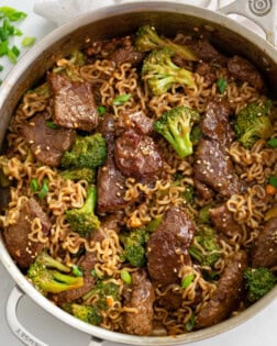 A skillet of Ramen Noodles with Beef and Broccoli in a brown sauce.