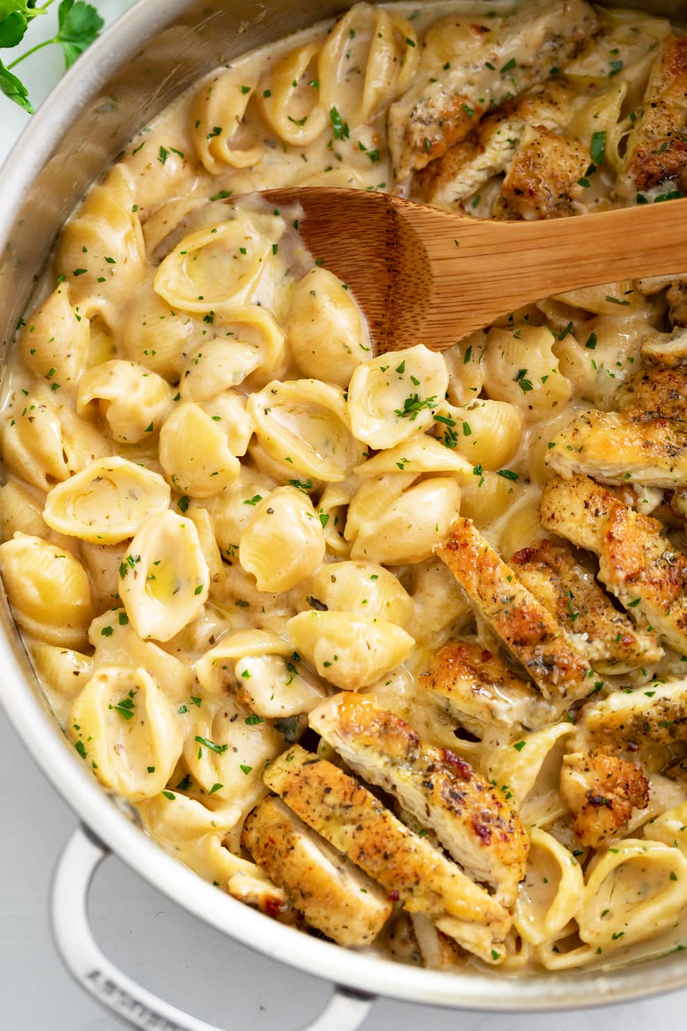 A skillet filled with Creamy Chicken Pasta with pasta shells and seared chicken strips. 