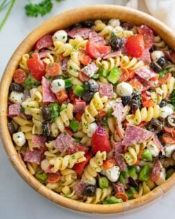 Italian Pasta Salad in a wooden bowl with Rotini Pasta, Salami, Pepperoni, Mozzarella, and more.