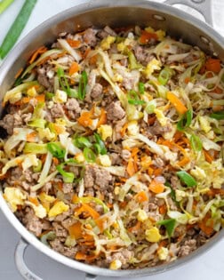 A skillet filled with Egg Roll in a Bowl with cabbage, carrots, pork, and scrambled eggs.