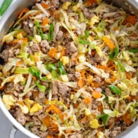Egg Roll in a Bowl in a skillet with ground pork, cabbage, carrots, and sauce.
