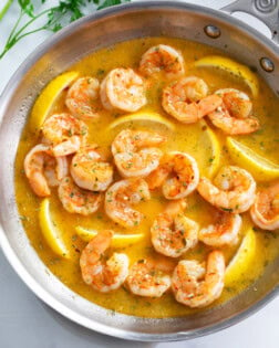 Garlic Butter Shrimp in a skillet with a buttery garlic sauce and lemon wedges.