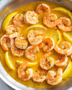 Garlic Butter Shrimp in a buttery garlic sauce with lemon wedges in a skillet.