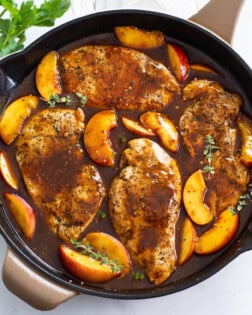 Peach Chicken in a skillet with Balsamic sauce and fresh thyme.