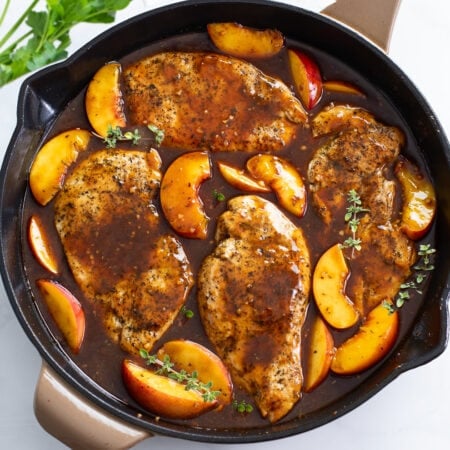 Peach Chicken in a skillet with Balsamic sauce and fresh thyme.