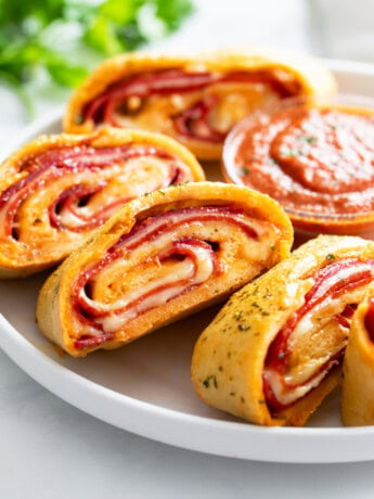 Slices of Stromboli on a white plate with parsley in the background.