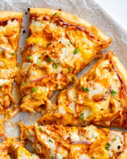 Slices of Buffalo Chicken Pizza with blue cheese and buffalo sauce.