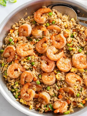 A skillet of Shrimp Fried Rice with shrimp, carrots, peas, and eggs.