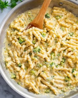 Cheese Pasta in a stainless steel skillet with a wooden spoon.