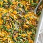 Green Bean Casserole in a baking dish with a spoon scooping it up.