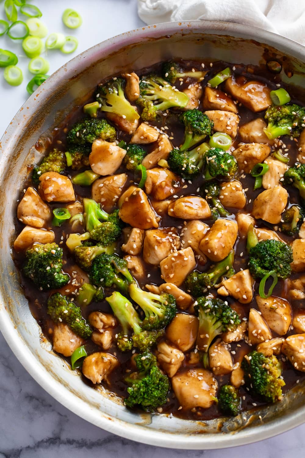 Teriyaki Chicken in a skillet with brown sauce, chicken, and broccoli.