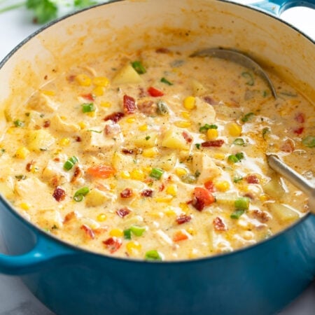Chicken Corn Chowder in a blue soup pot with a ladle on the side.