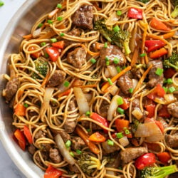 Beef Lo Mein in a skillet with brown sauce and vegetables.