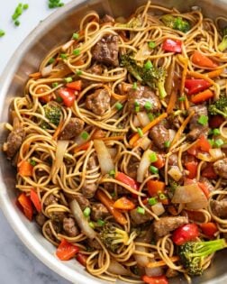 Beef Lo Mein in a skillet with brown sauce and vegetables.