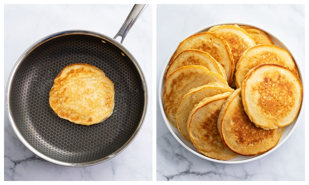 A cooked pancake in a skillet next to a plate of golden cooked pancakes.