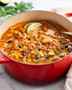 Chicken Taco Soup in a Dutch oven with corn, black beans, and lime slices.