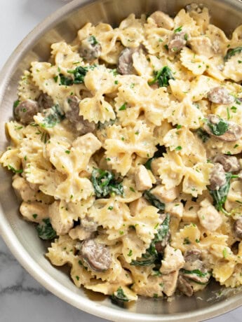 Mushroom Chicken Pasta in a skillet with creamy sauce and spinach.