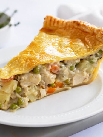 A thick slice of double crust Chicken Pot Pie with a creamy filling with chicken, potatoes, and vegetables.