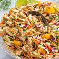 Thai Chicken Salad in a large bowl with cabbage, chicken, peanut dressing, and vegetables.