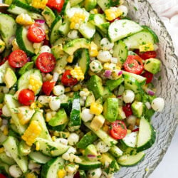 A glass bowl filled with Cucumber Avocado Salad.