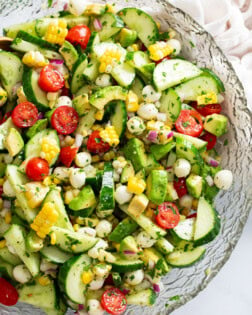 A glass bowl filled with Cucumber Avocado Salad.