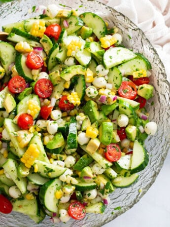 A glass bowl filled with Cucumber Avocado Salad.