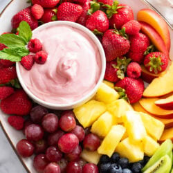 Overhead view of a platter of Fruit with Fruit Dip in a bowl on the side.