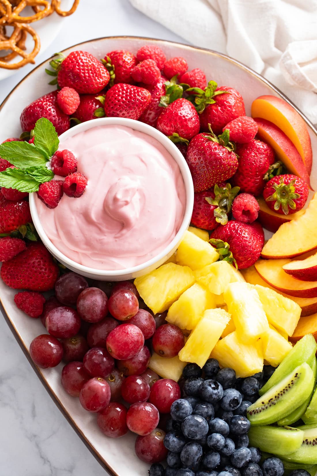 Overhead view of a platter of Fruit with Fruit Dip in a bowl on the side.