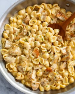 Chicken Mac and Cheese in a skillet with a wooden spoon.