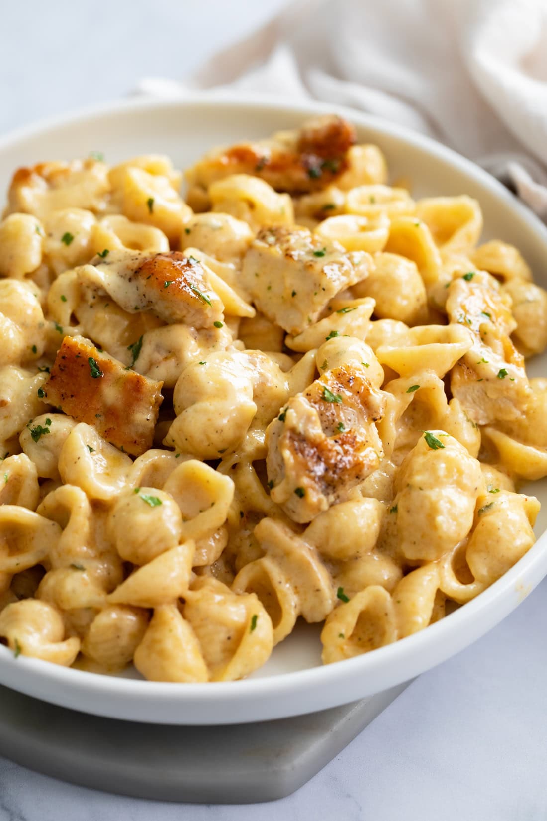 Side view of Chicken Mac and Cheese on a white plate.