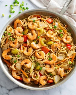 Shrimp Lo Mein with vegetables and sauce in a stainless steel skillet.