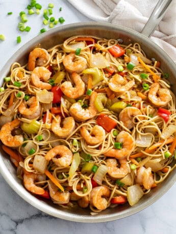 Shrimp Lo Mein with vegetables and sauce in a stainless steel skillet.